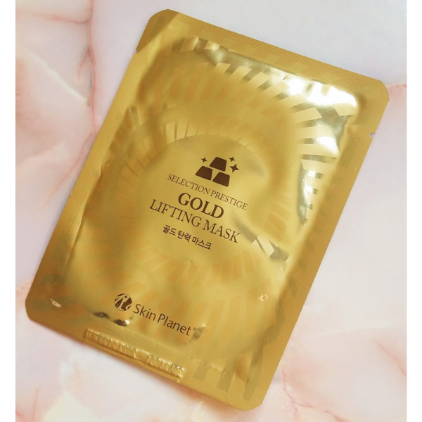 Masque visage gold lifting Skin Planet posé sur fond marbré effet raffermissant